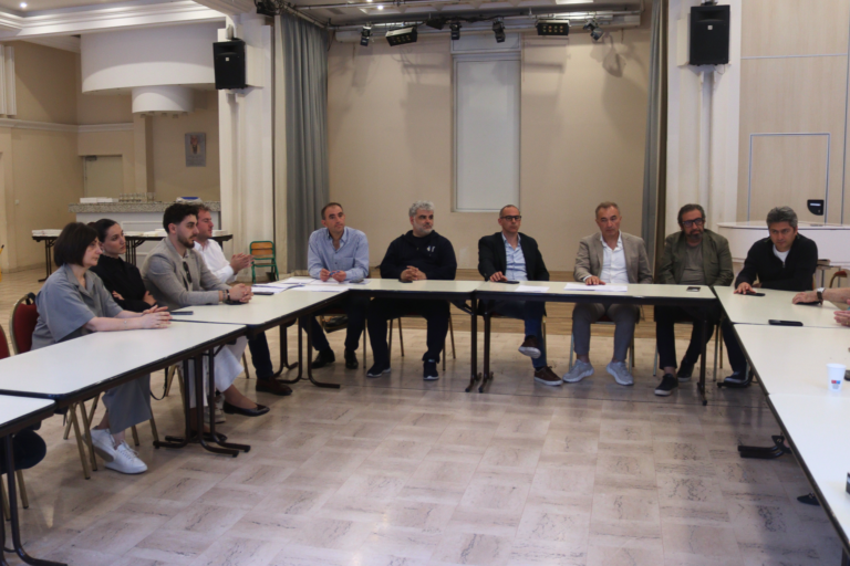 Les participants de l'assemblée générale assis à la table